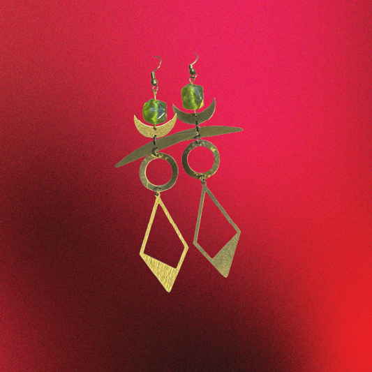 Pair of gold and green earrings on a red background